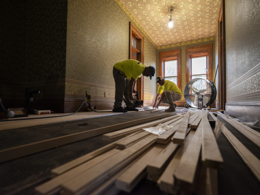2 carpenters installing wood flooring