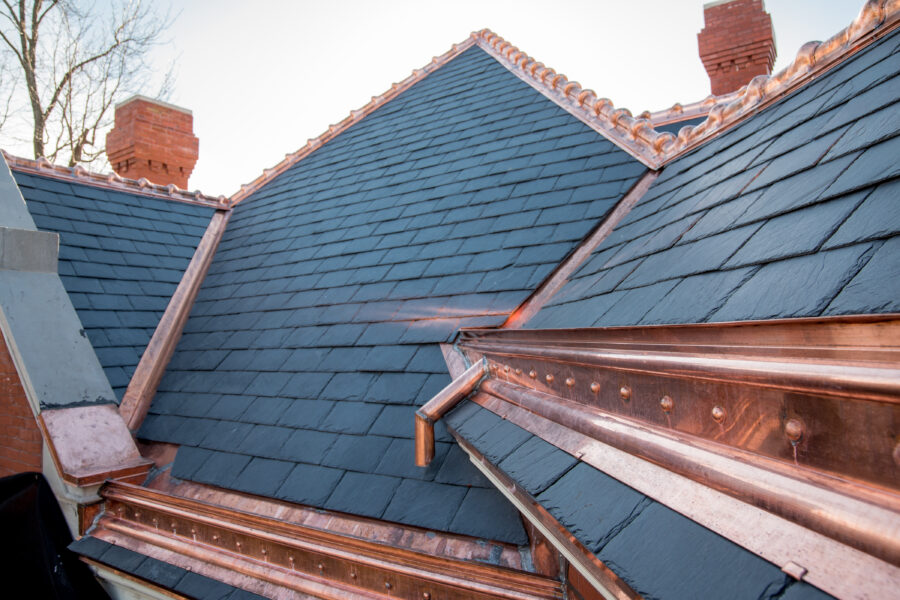 Detail shot of the Buckingham slate roof with brand new custom copper cresting, flashing, gutters, and downspouts.